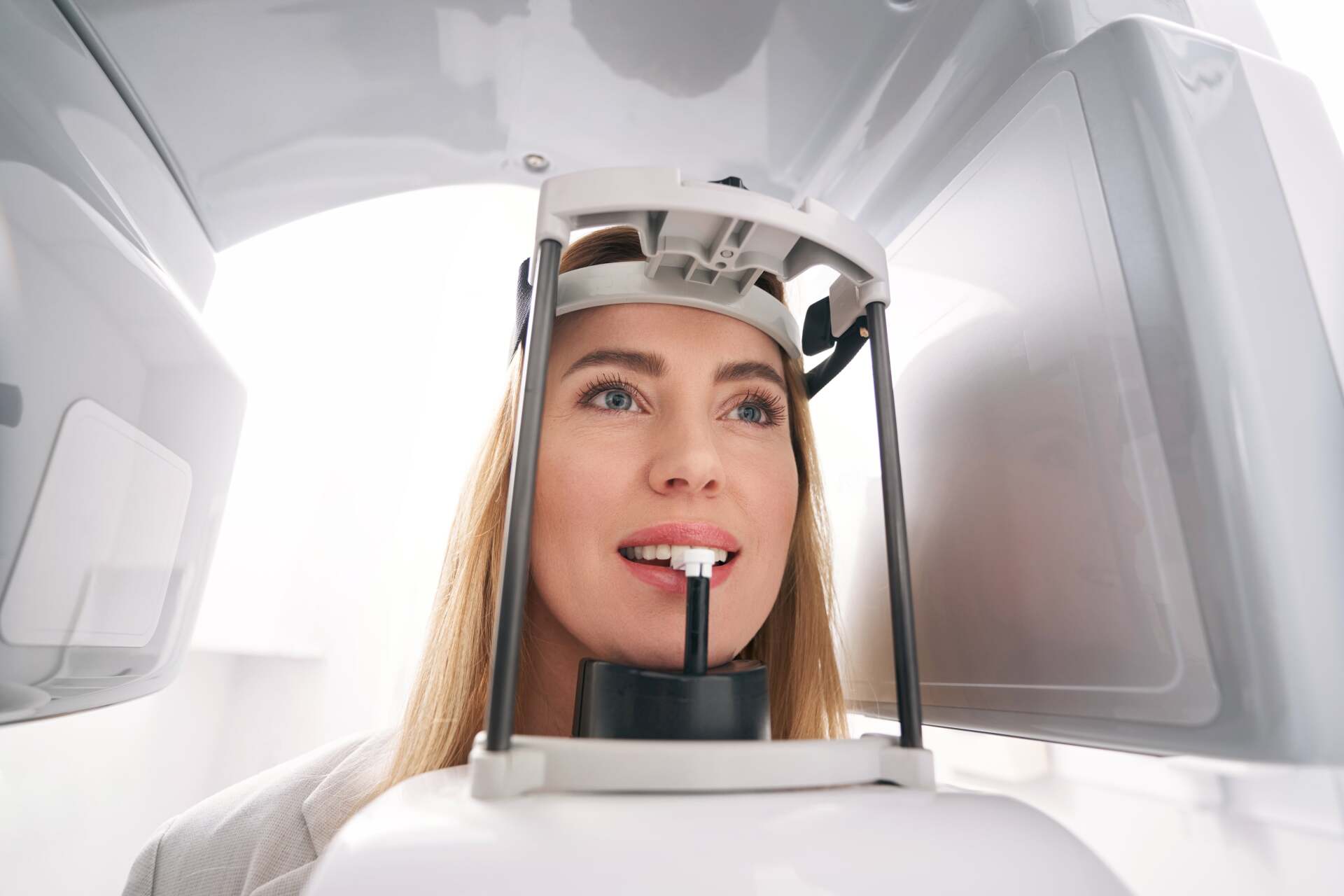 A woman is getting an x-ray of her teeth in a dental office.