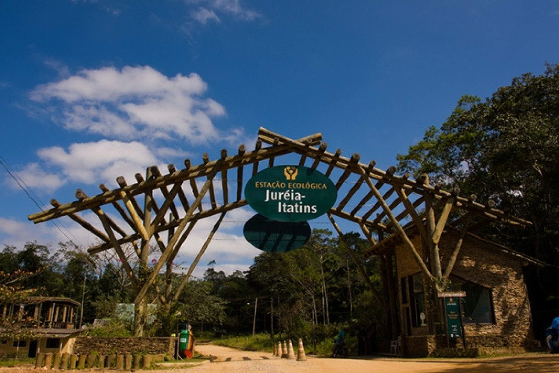 Entrance archway to Estação Ecológica Juréia-Itatins, Brazil, with wooden structure under blue sky.