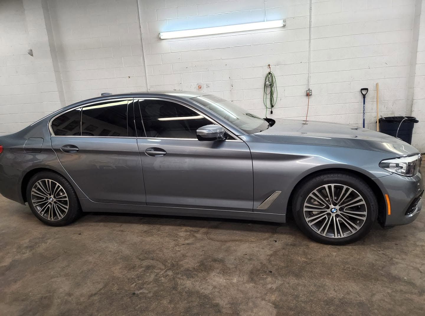 Silver sedan parked indoors in a garage, side view