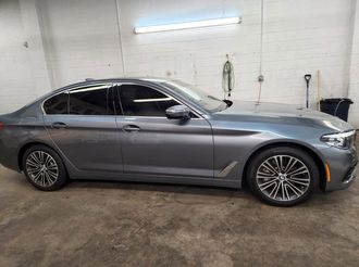 Silver sedan parked indoors in a garage, side view
