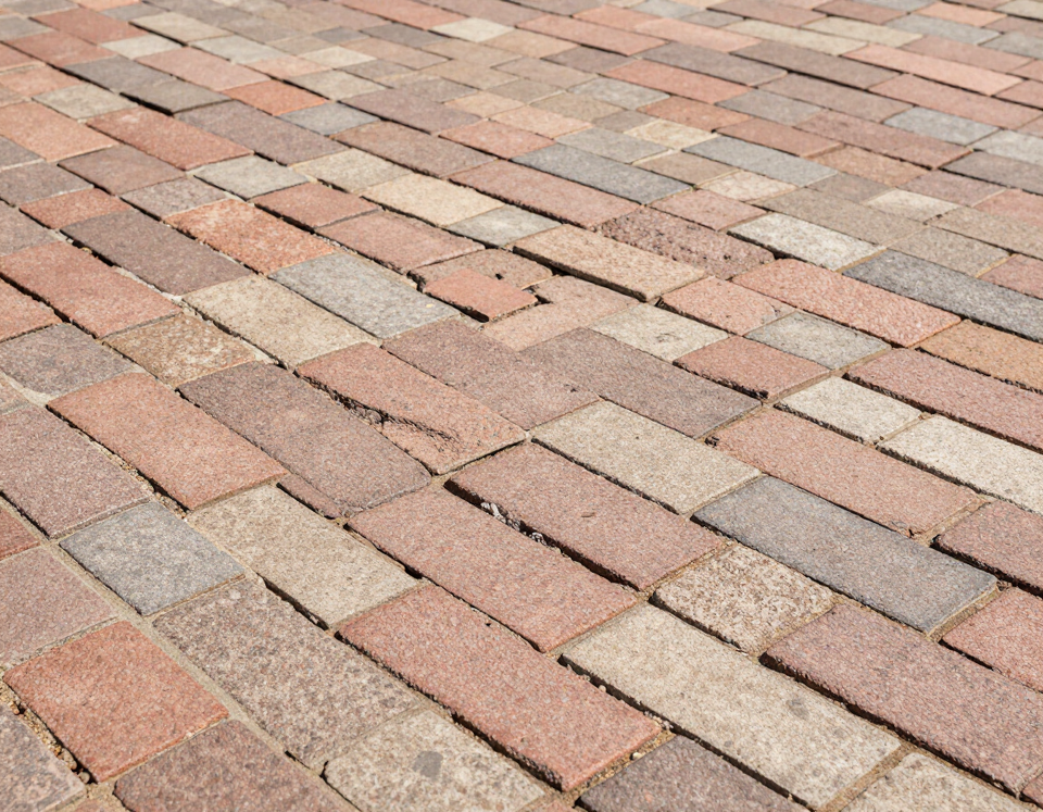 Interlocking pavers in herringbone pattern showing color variation and mortar joints