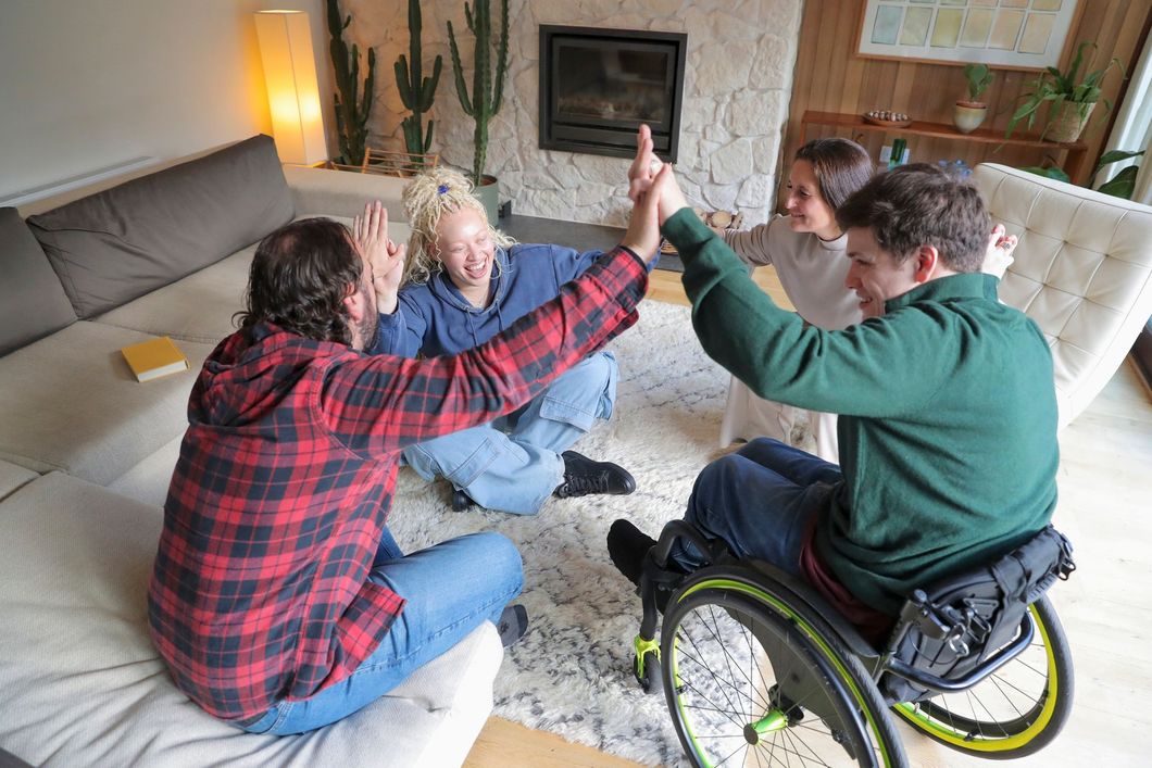 A group of people are putting their hands together in a circle.