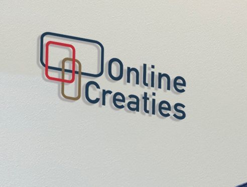 Een bordje aan de muur met de tekst online creaties