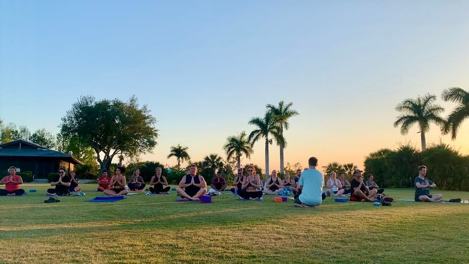 A group of people are doing yoga in a park.