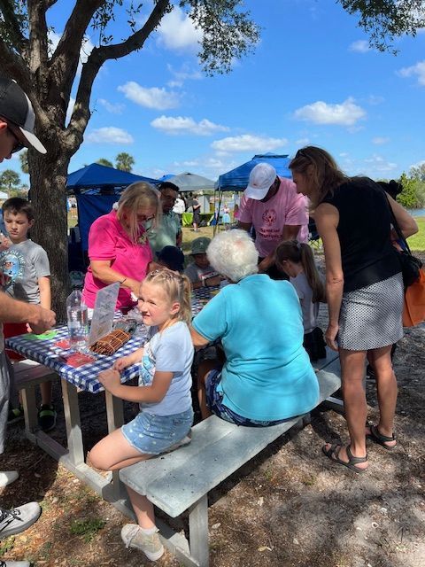 A group of people are gathered around a picnic table