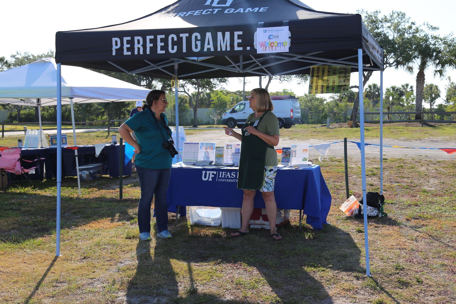 Two women standing under a perfect game tent