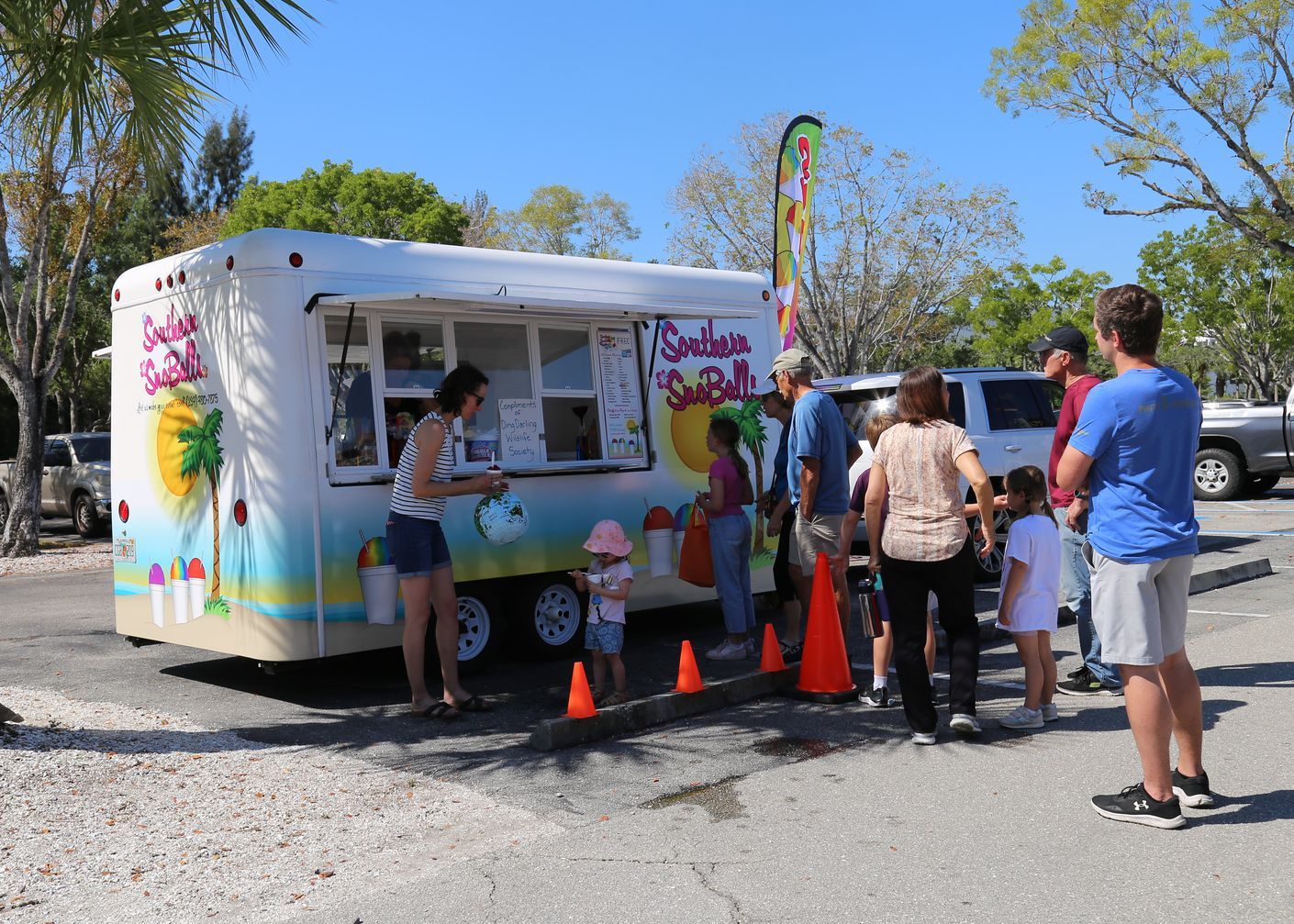 A group of people are standing in front of a food truck.
