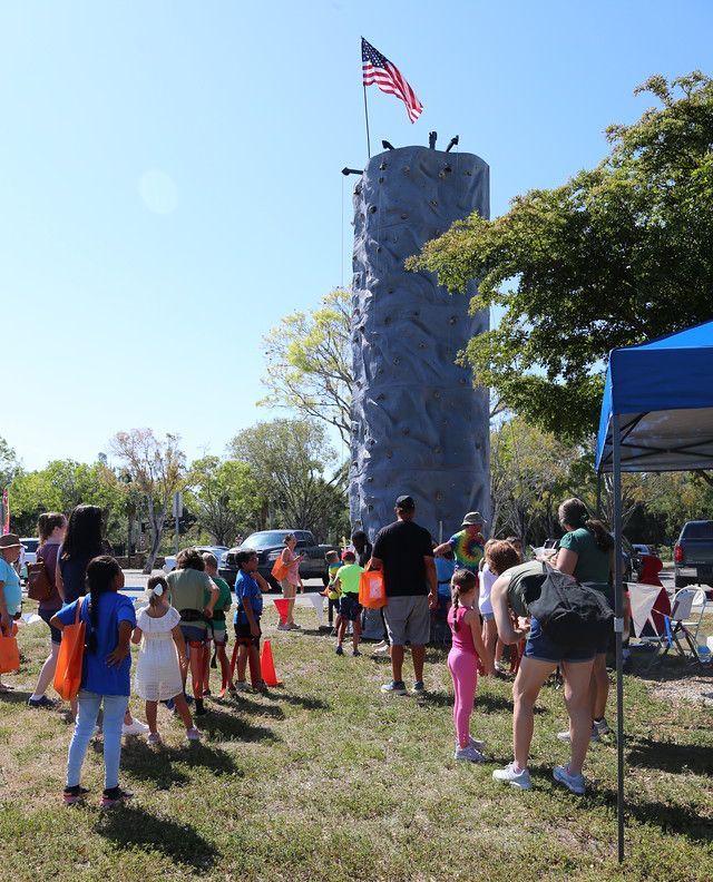 A group of people standing in front of a climbing wall