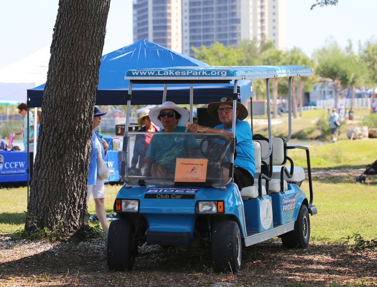 A group of people are riding in a blue golf cart