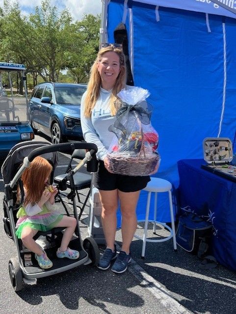 A woman is holding a basket in front of a blue tent