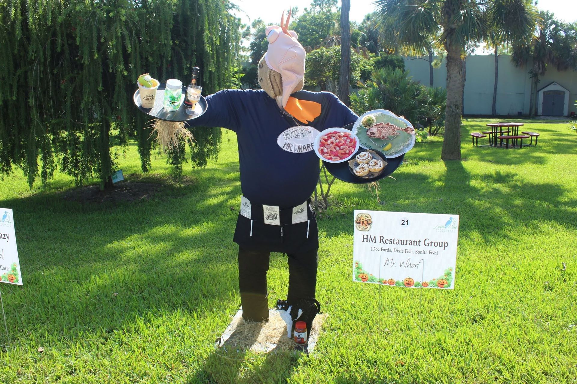 Person standing on grass holding two flower bouquets in a sunny park