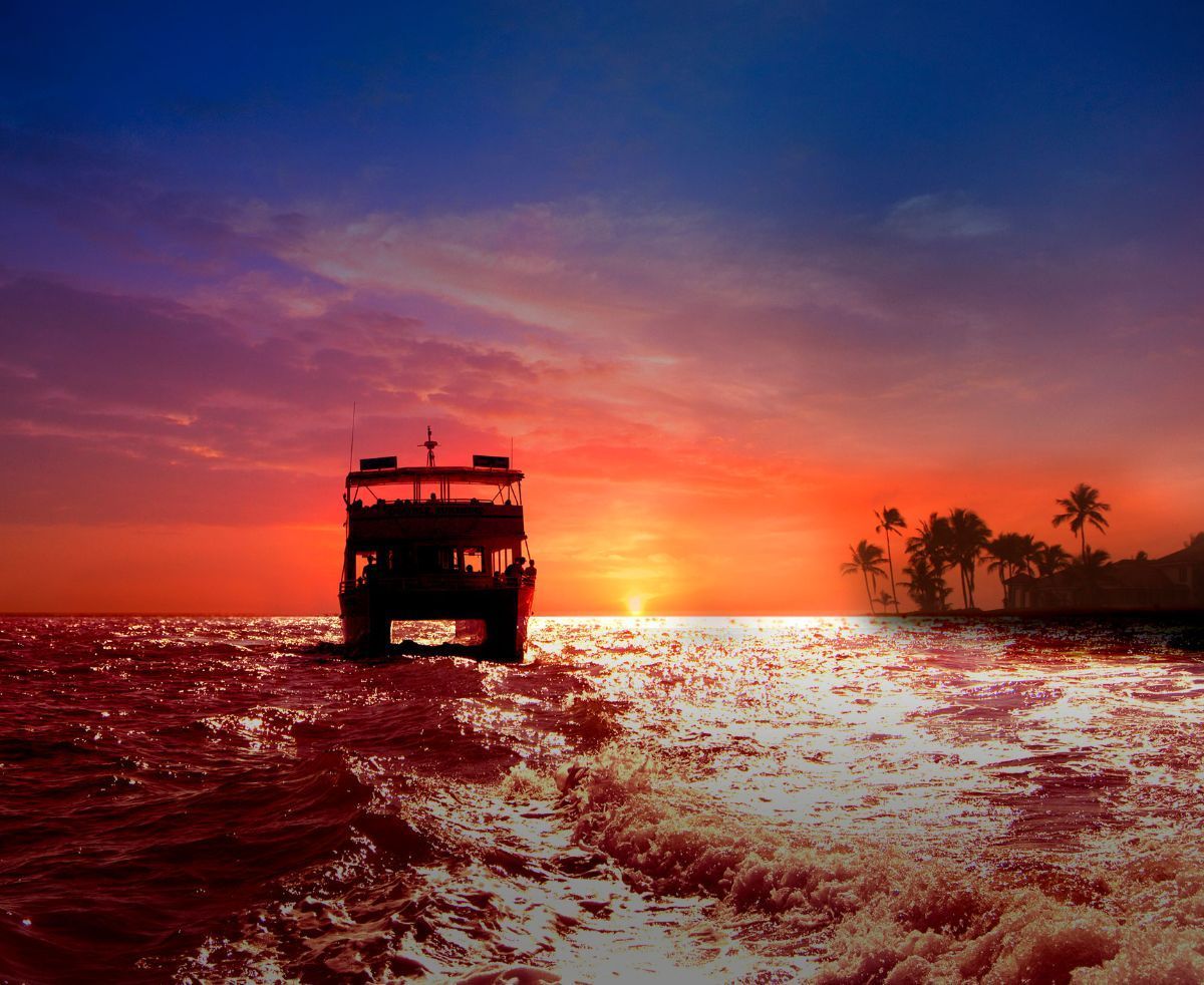 A boat is floating in the ocean at sunset