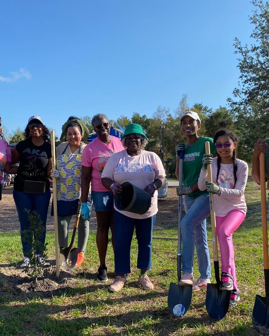 A group of people standing next to each other holding shovels.