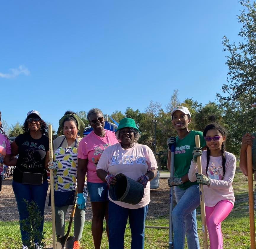 A group of people standing next to each other holding shovels