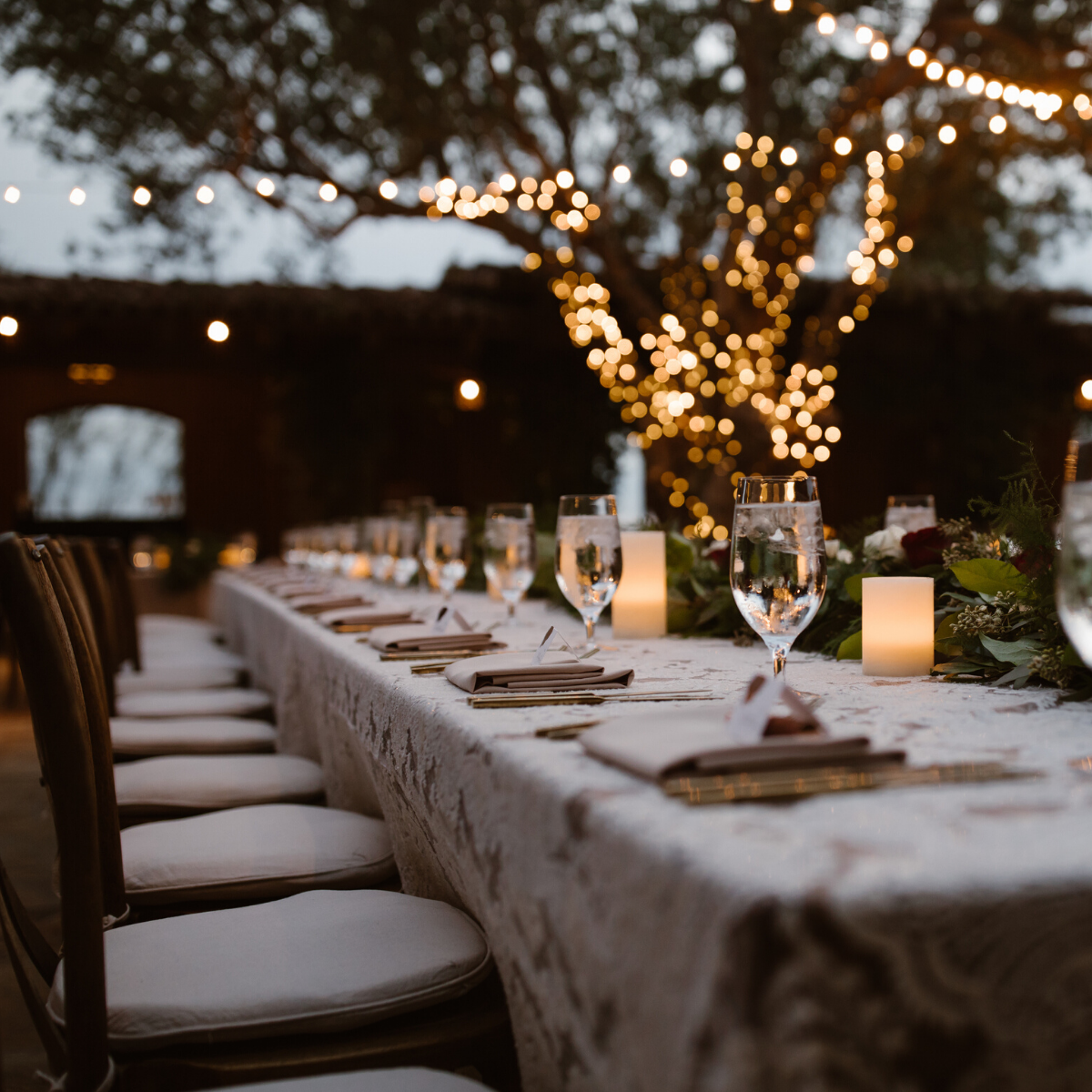 A long table with glasses and candles on it