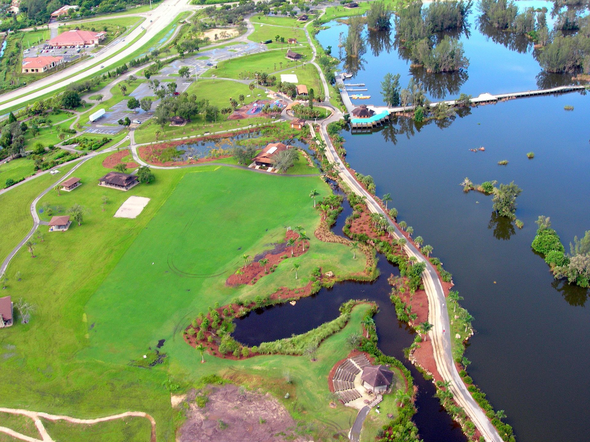 An aerial view of a golf course with a lake in the middle