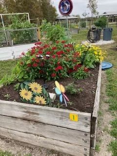A wooden box filled with flowers and plants in a garden.