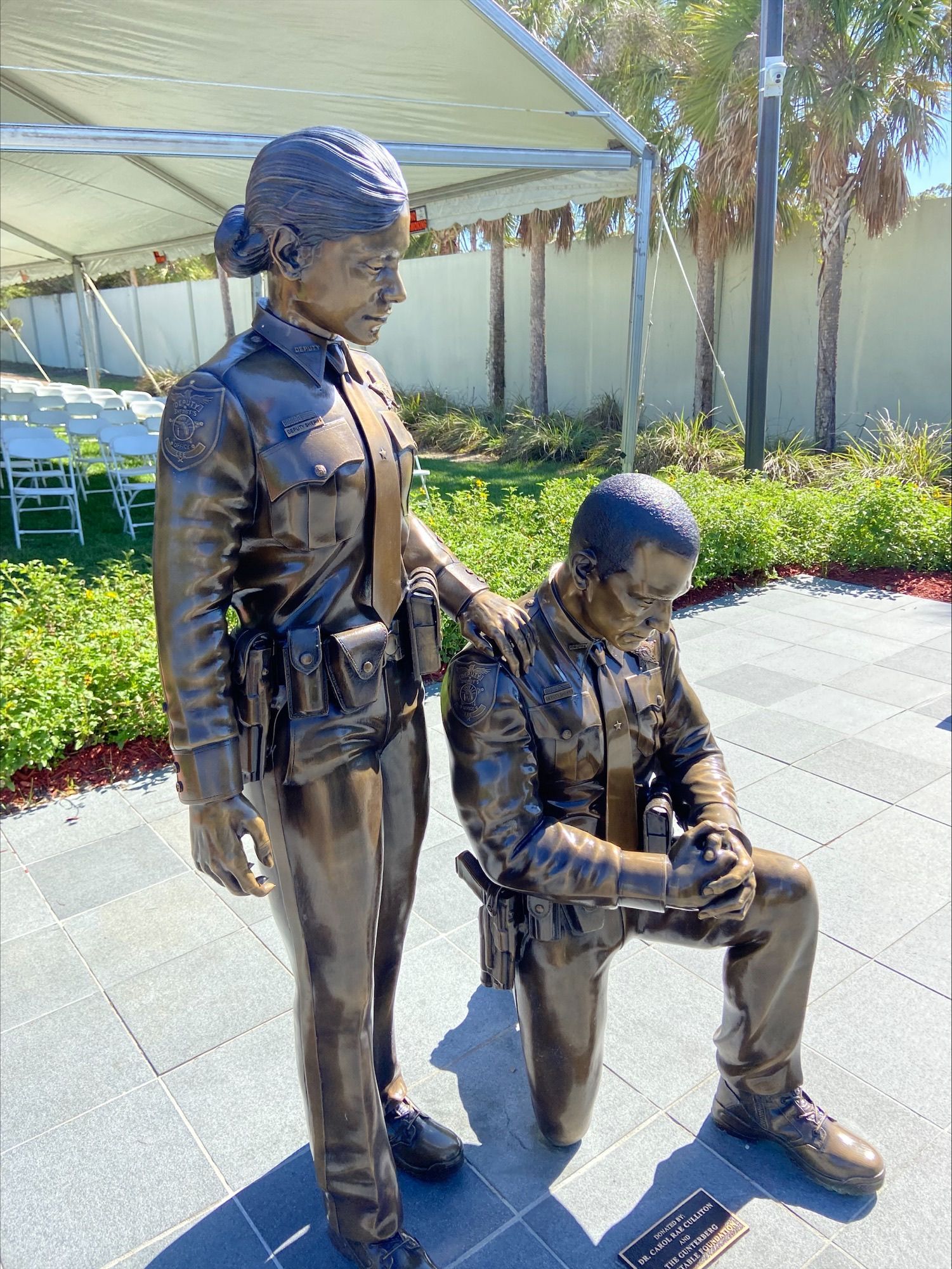 A bronze statue of a police officer and a man kneeling down.