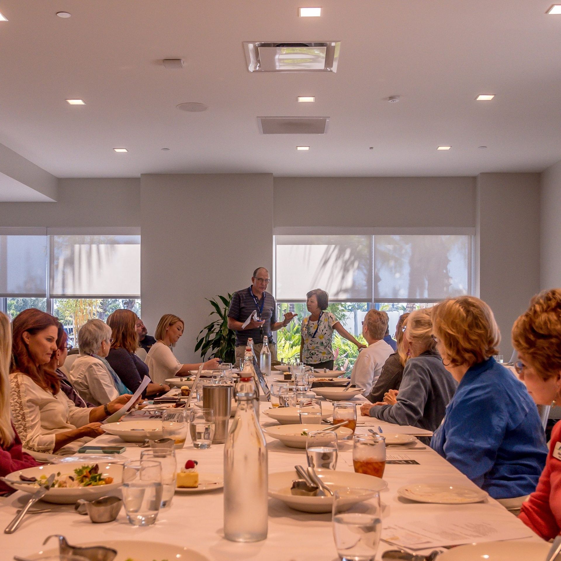 A group of people are sitting at long tables in a restaurant.