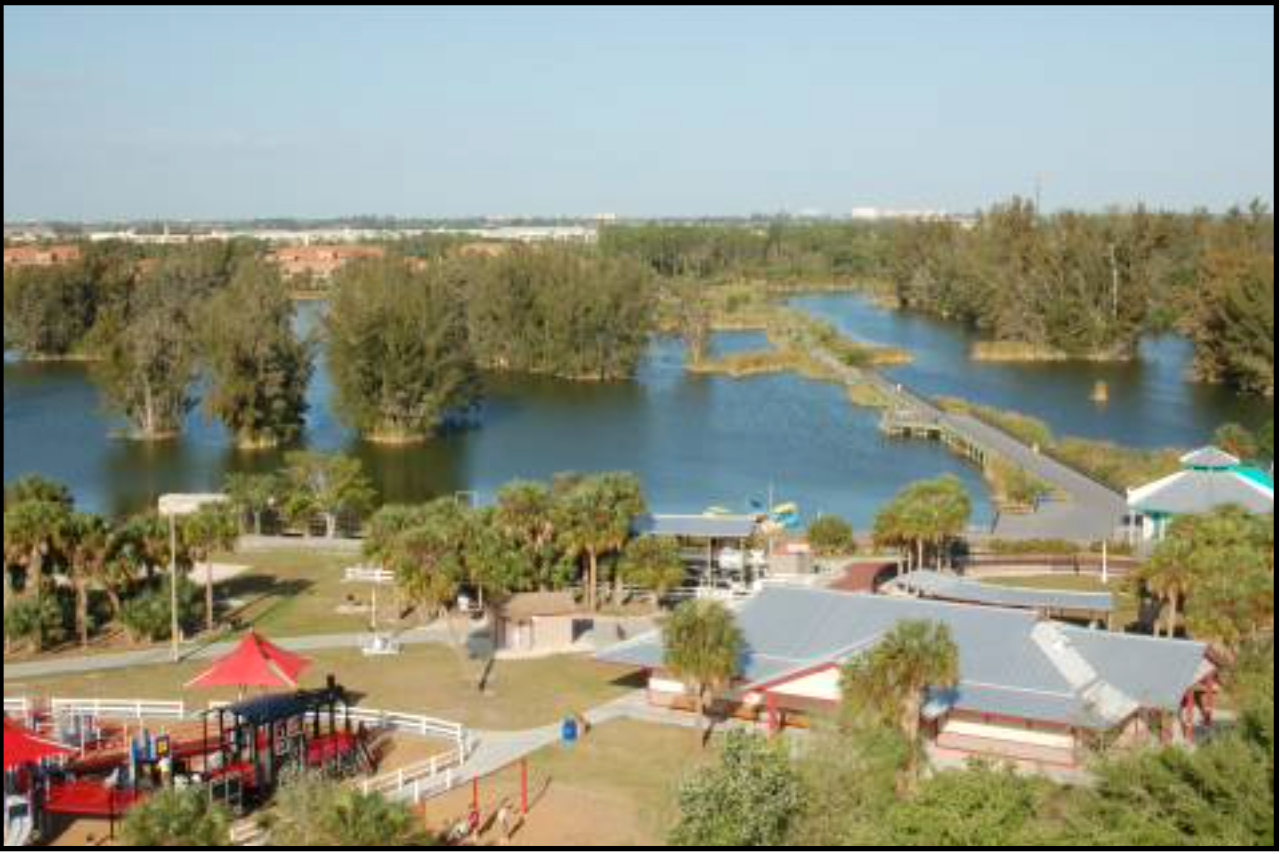 An aerial view of a lake with a playground in the foreground