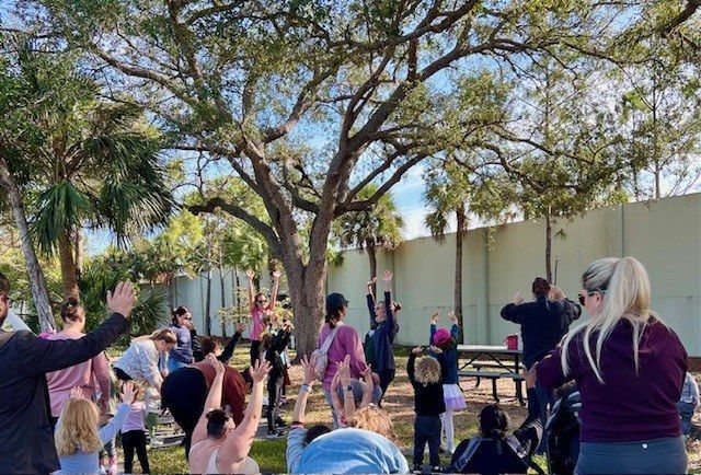 A group of people are doing yoga in a park.