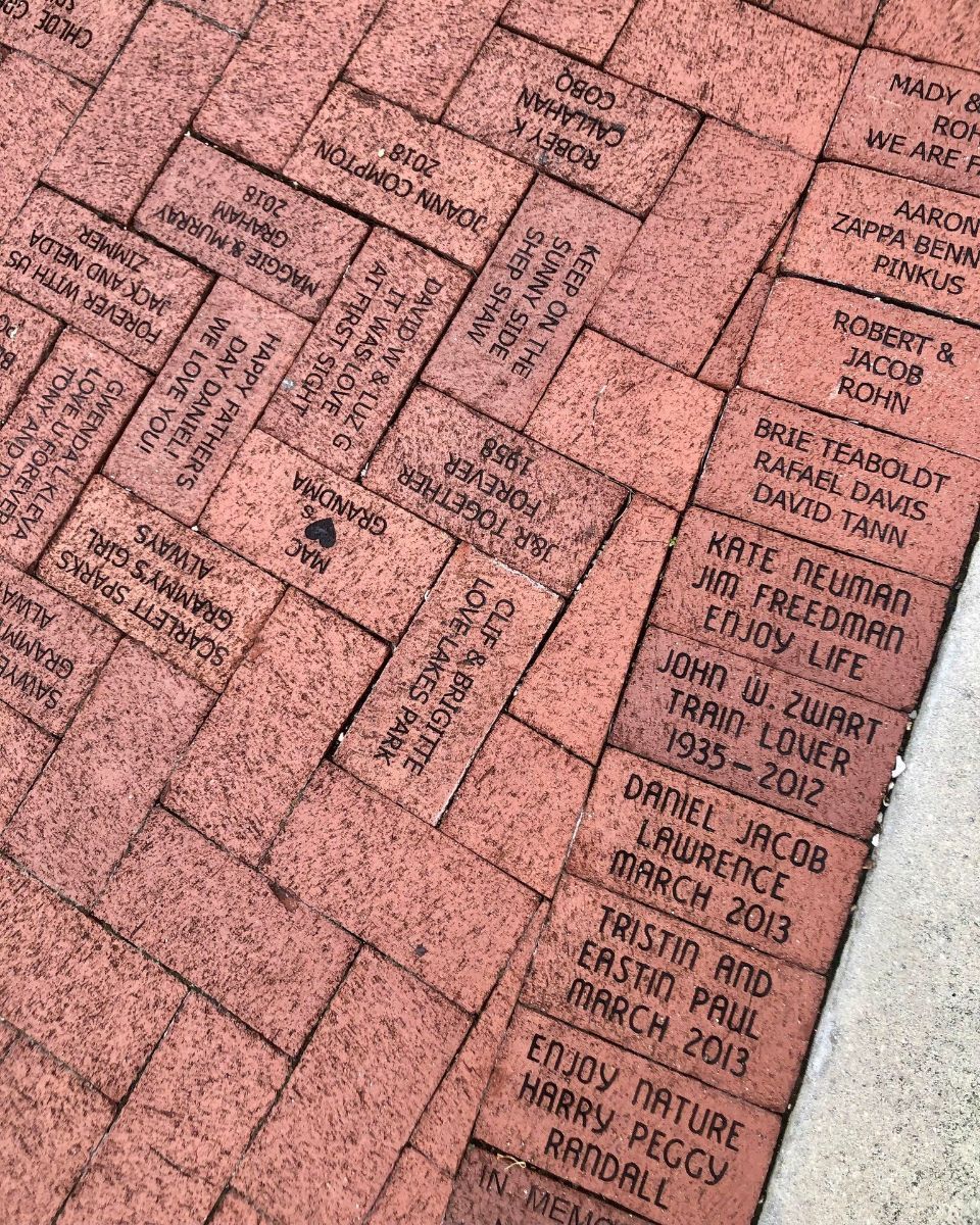 A close up of a brick walkway with names on it.