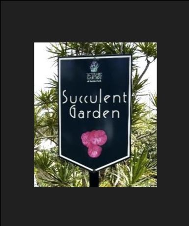 Sign for a succulent garden with white text and a pink flower illustration.