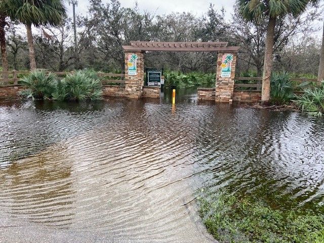 The entrance to a park is flooded with water.