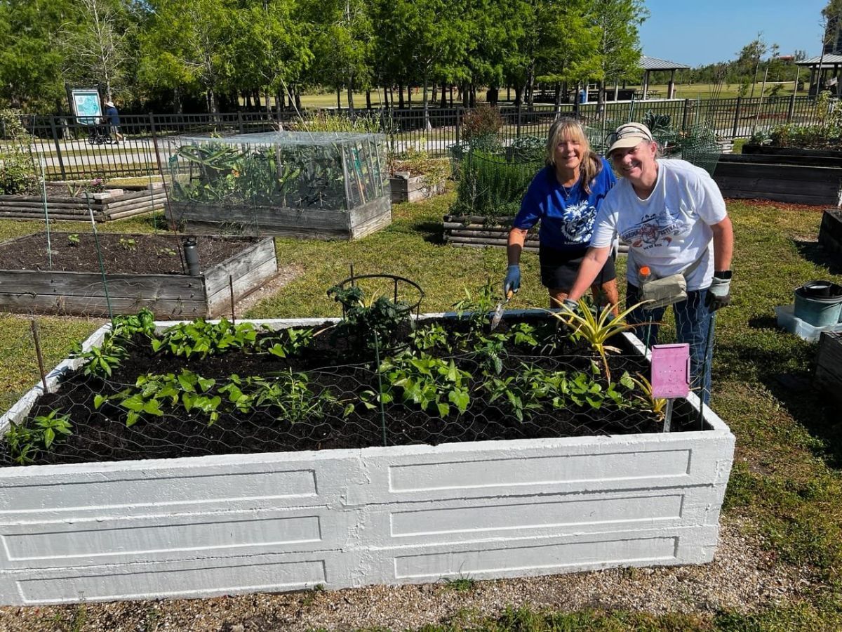 A man and a woman are working in a garden.