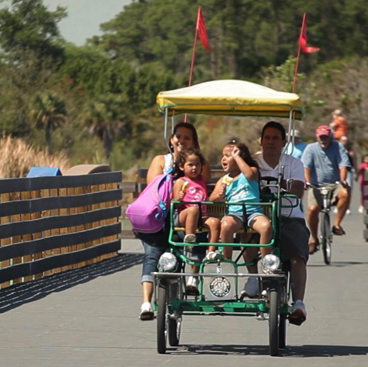 A group of people are riding in a cart with a canopy