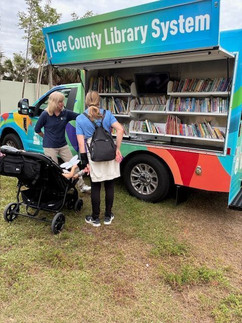 A Lee County Library System mobile unit with people browsing books.