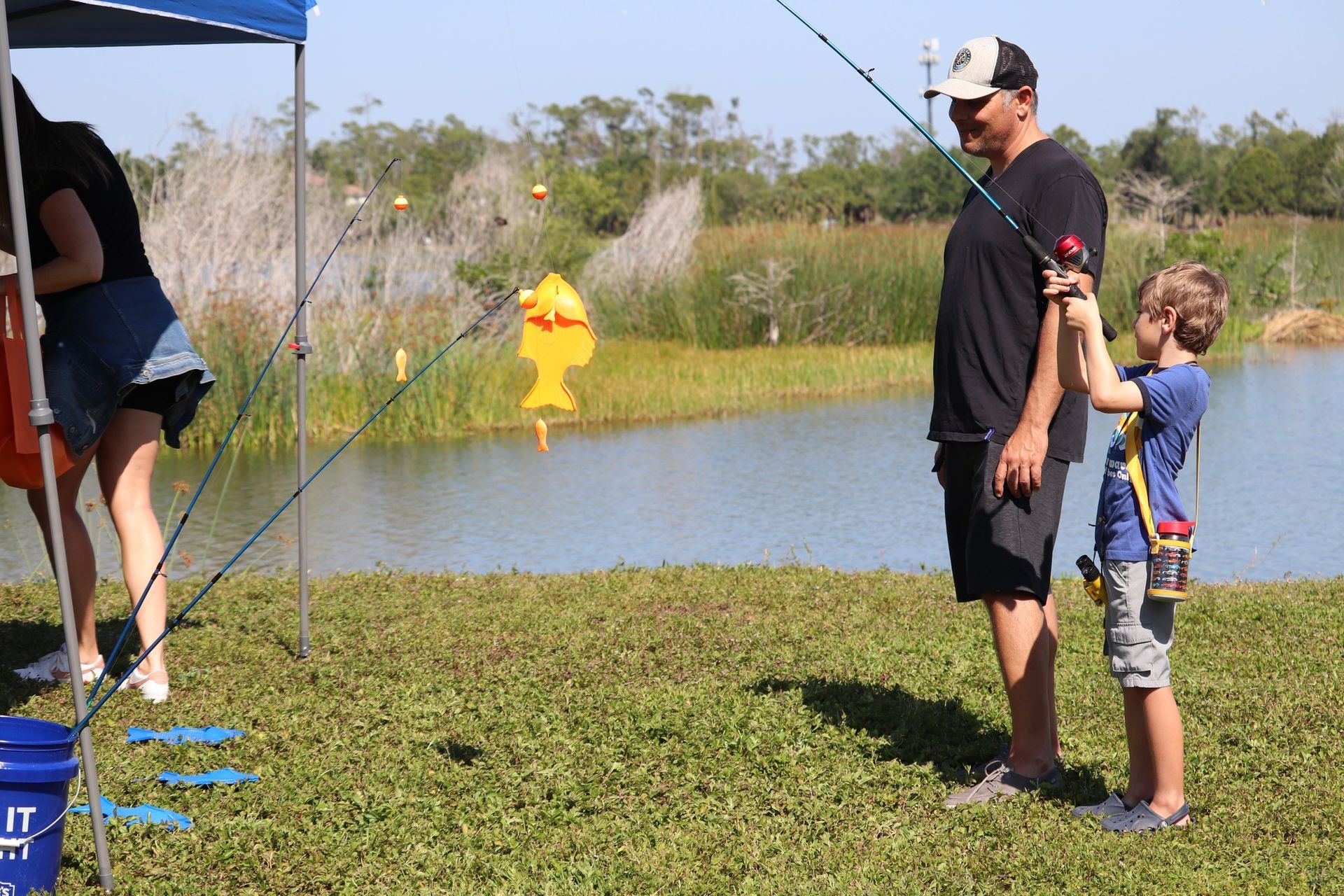A man and a boy are fishing in a pond.
