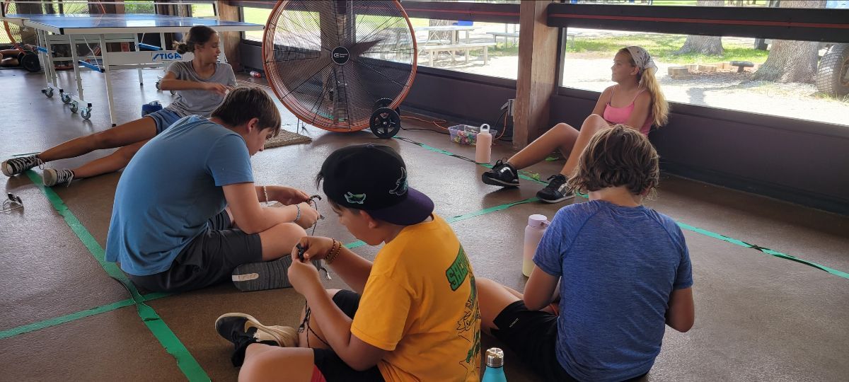 A group of people are sitting on the floor in a room.
