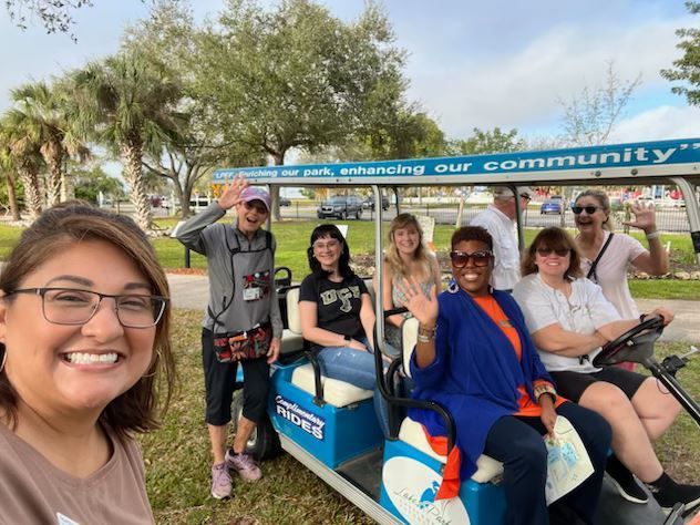A group of people are sitting on a golf cart that says community