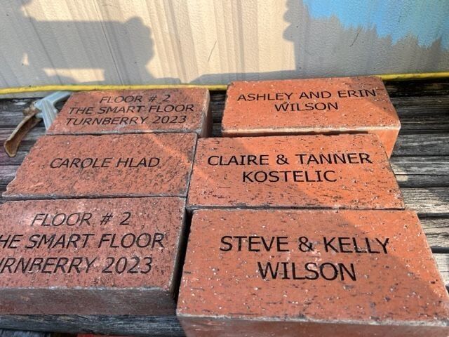 A stack of bricks with names on them including steve and kelly wilson
