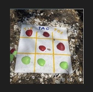 A tic tac toe game is sitting on the ground.