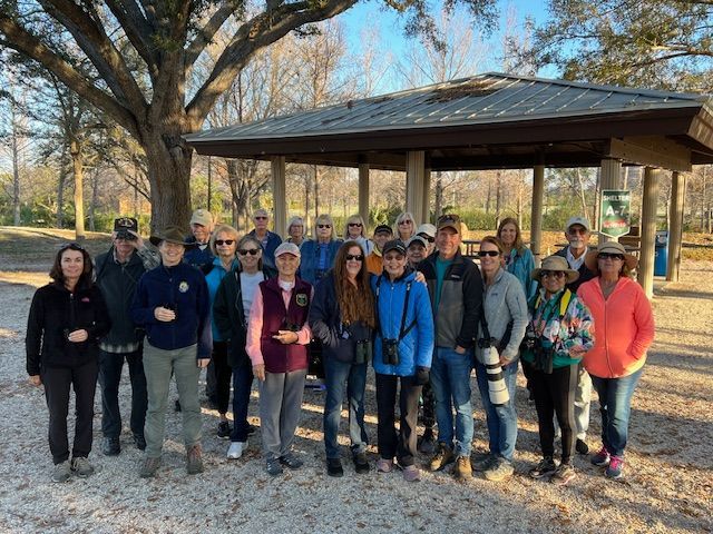 A group of people are posing for a picture in front of a pavilion.