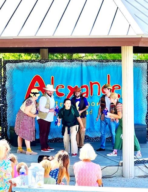 A group of people standing in front of a banner that says alexandre