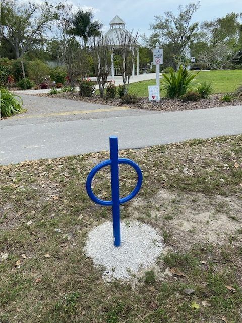 A blue bike rack with the letter p on it