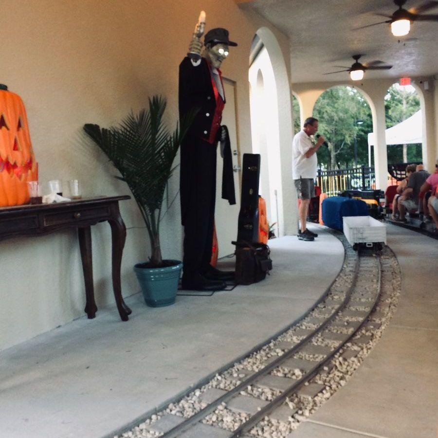 A man playing a trumpet in front of a table with a pumpkin on it