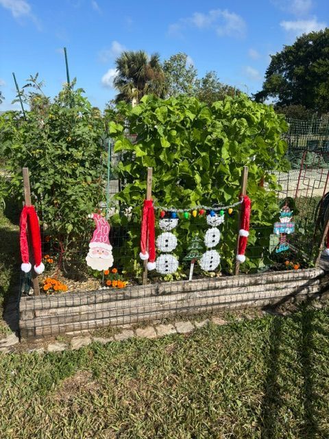 A garden is decorated for christmas with santa hats and snowmen
