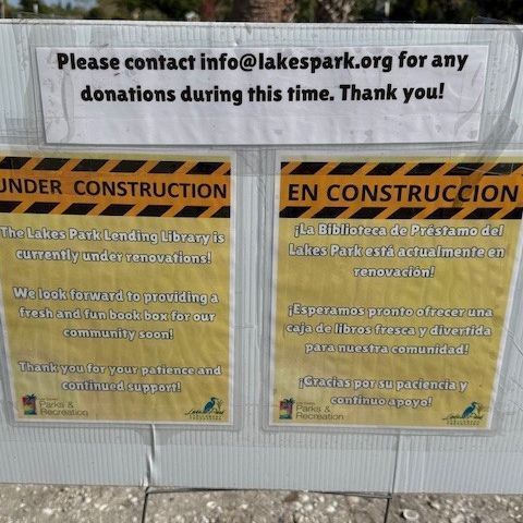 Sign: Lakes Park Lending Library under renovation, in English and Spanish. Contact info@lakespark.org for donations.