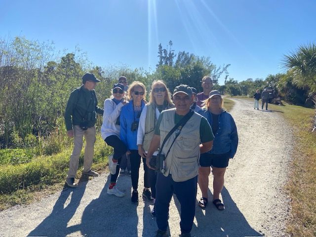 A group of people are walking down a dirt road.