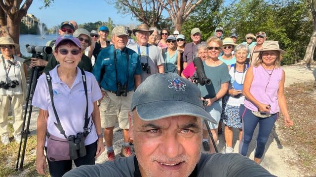 A man is taking a selfie with a group of people.