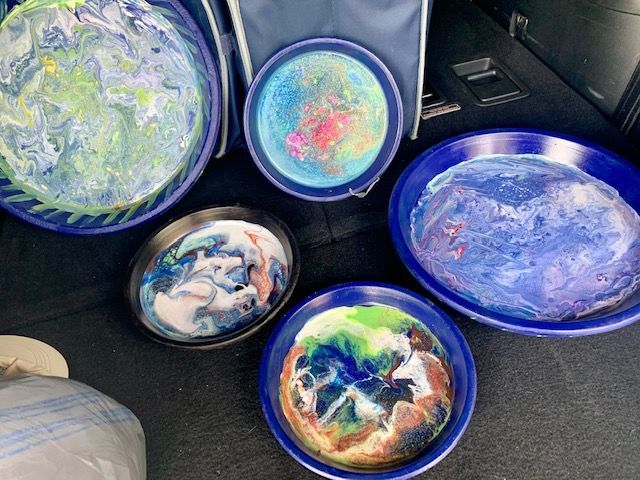 A bunch of bowls are sitting on the back of a car.