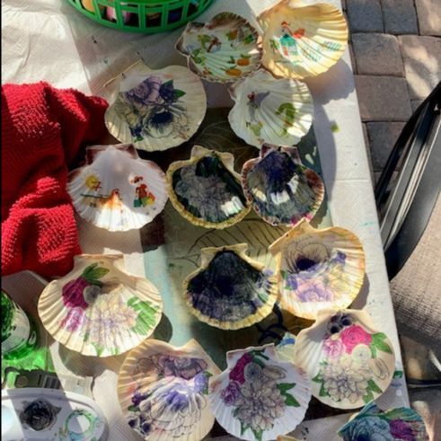 Several shells with flowers painted on them are on a table