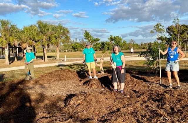 A group of people are standing in a pile of dirt.