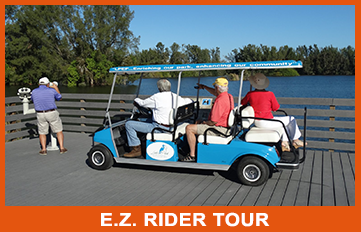 A group of people are riding a blue golf cart on a dock ..