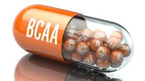 Orange and clear capsule spilling small, round BCAA (Branched-Chain Amino Acid) capsules.