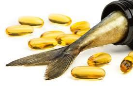 Fish tail protruding from a black bottle with fish oil capsules scattered around.